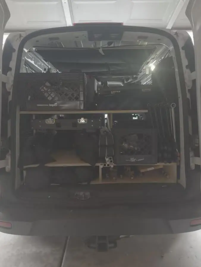 Rear view of the RCK van build with cases, carts, and stands